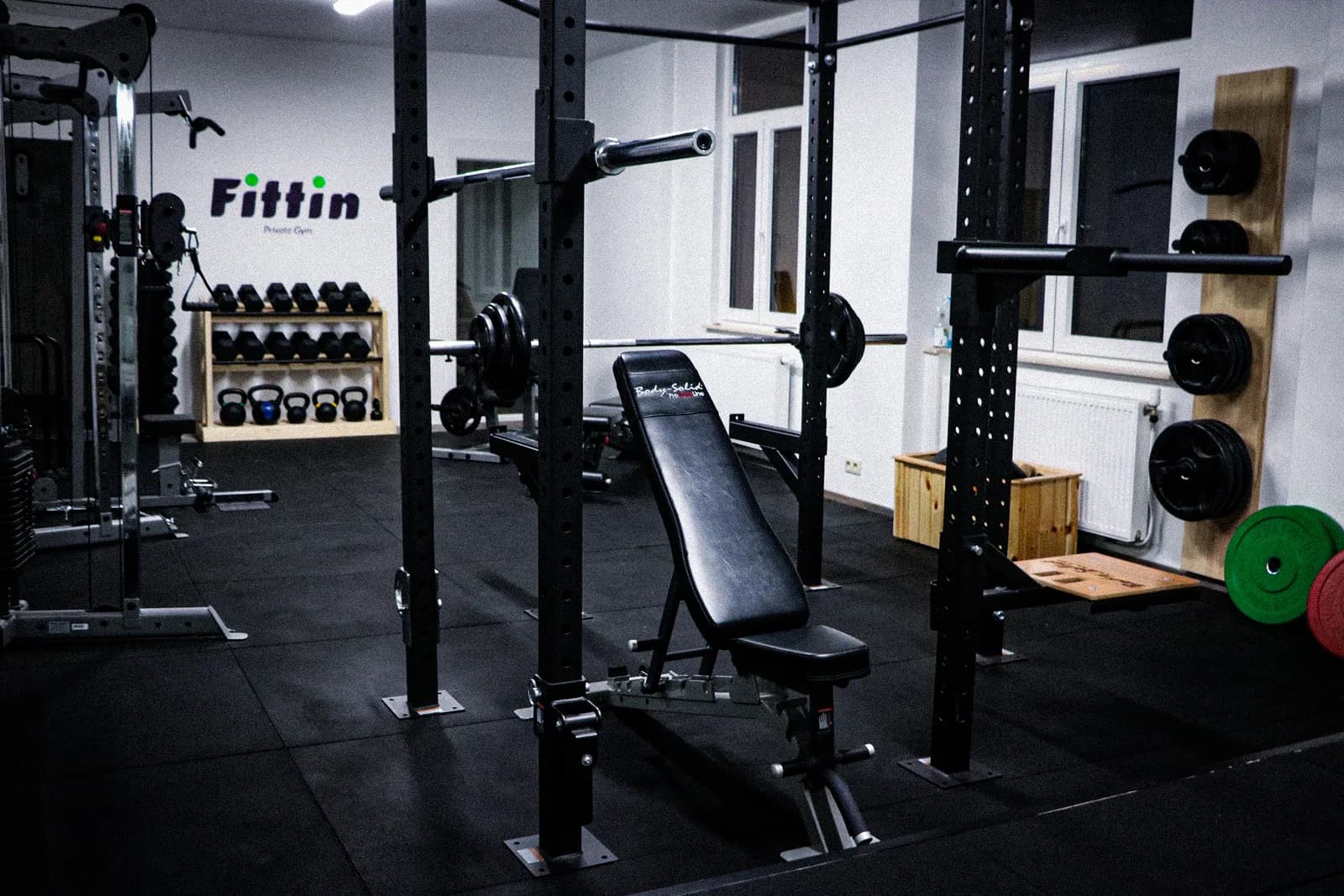 De trainingszaal van Fittin’ met het rek, de bank en de vrije gewichten
